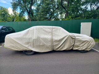 Vehicle parked outdoors with nylon protective cover shielding from dust rain and sunlight exposure © Harmony Video Pro