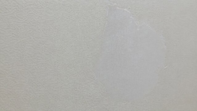Close-up of a repaired wall showing texture difference between old and new patch.