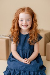 Naklejka premium Smiling redhead girl portrait with stacked presents for birthday card background and children's party poster design