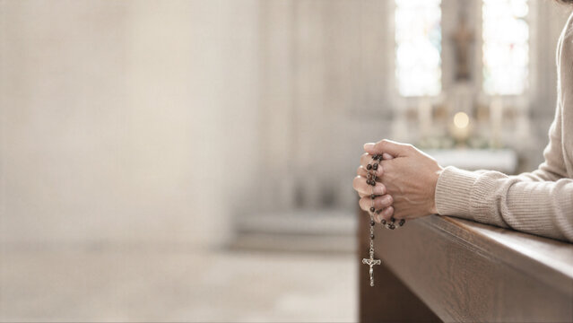 Woman holding rosary beads while praying in church. Devout believer in quiet reflection during religious service. Catholic faith concept for spiritual meditation and worship.