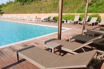 Fototapeta premium Luxury poolside terrace with sun loungers on a sunny summer day