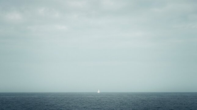 Small sailboat on the open ocean under a cloudy sky