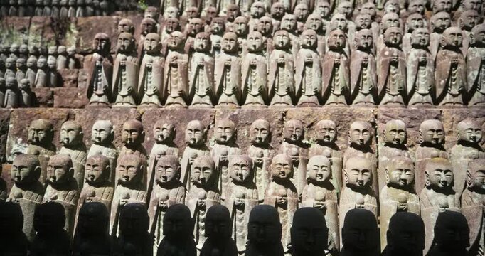 Hundreds of Jizo Stone Statues Tiered Wall,  Slow Pan Reveal In Japan