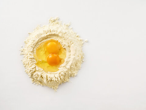 Flour with fresh eggs ready for dough preparation, baking concept for home cooking and culinary enthusiasts