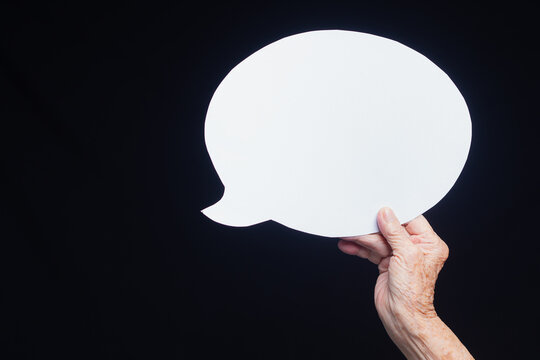 Senior Woman Hand Holding Blank Speech Bubble on Dark Background