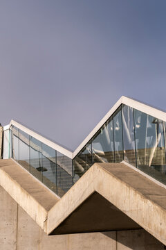 Zigzag stairs cut through concrete architecture, where glass, exterior, urban steps, geometry, handrail and design sharpen the roofline