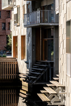 Across the water, stairs and housing meet balconies on a facade, where exterior urban residential steps shape architecture in daylight