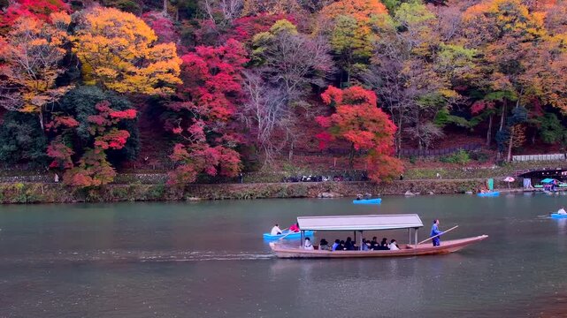 紅葉の京都渡月橋前の桂川で船遊び　