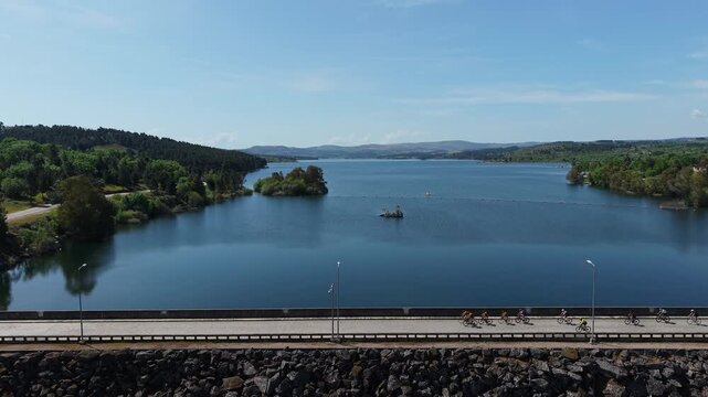 Dam stone riprap wall and road overlooking vast Douro reservoir with island forested banks and hills