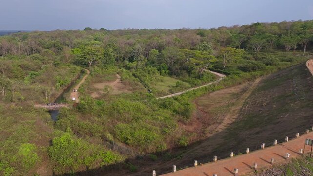 Reveal shot of Chiklihole Reservoir with mud road, bridge, Chichle Canal and attur forest at Coorg, Madikeri, karnataka, india. day time, push back shot, drone shot, 4k.