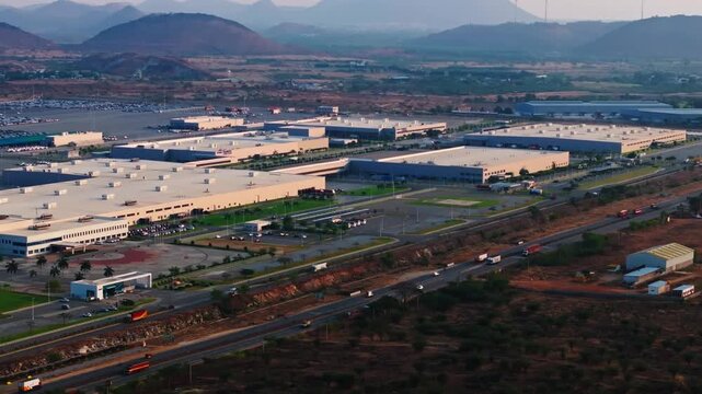 Aerial view of kia manufacturing unit with NH44, hills, KIA Helipad and Dispatch Yard at Penukonda, Munimadugu, Anantapur, andhra pradesh, india. day time, semi circle shot, drone shot, 4k.