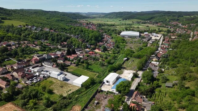 An expansive aerial perspective showcases a village in Hungary, with ongoing construction juxtaposed against vibrant natural landscapes.