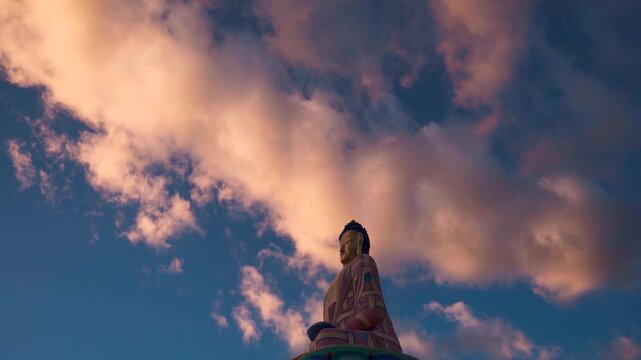 Langza Buddha statue on a cloudy day during sunset at Spiti Valley, Himachal Pradesh, India. Old golden Buddha statue against sky. Travel and holidays concept.