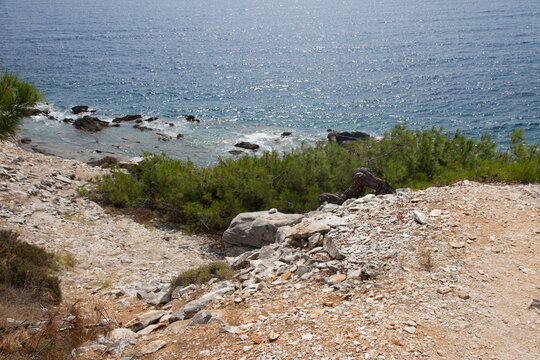 High-angle scenic view of a rocky cliff and sandy beach in Alyki, Thassos, Greece.