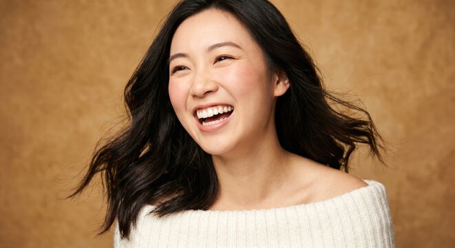 Smiling Asian woman with long dark hair on brown background