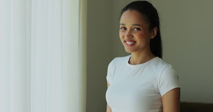 Portrait of a sporty and smile woman looking at the camera resting after training at home. Beautiful healthy sportive girl athlete resting after intense hard training.