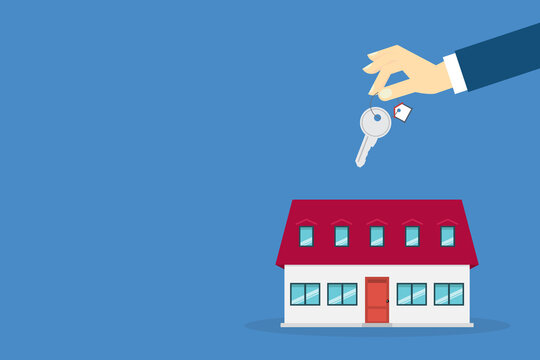 Hand holding key over the house. House buying	