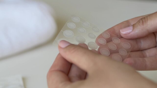 Close-up of transparent acne stickers designed for pimple recovery and skin care. Suitable for Korean beauty campaigns, dermatology products and cosmetic skincare brands.