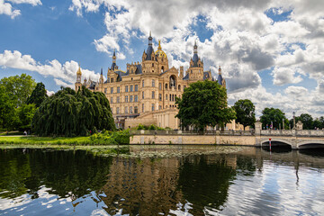 Obraz premium Schwerin Palace with Stone Bridge and Water Reflection in Mecklenburg