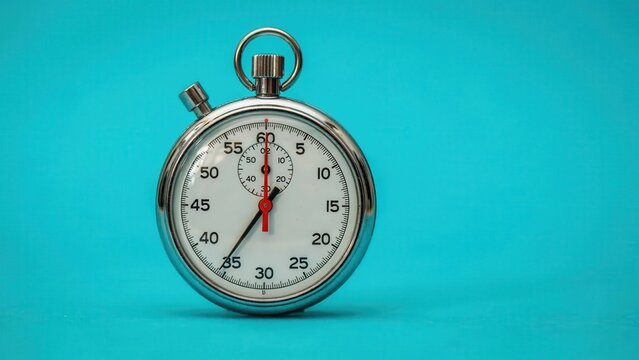 A close-up view of a stopwatch on a teal background shows time passing quickly.