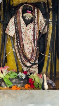 Lord Shani Dev draped in traditional cloth and Rudraksha garlands, beautifully decorated with flowers inside a Hindu shrine, symbolizing justice, discipline, and divine protection.