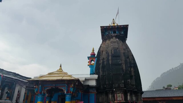 Omkareshwar Temple in Ukhimath stands gracefully against rain-soaked Himalayan mountains and drifting monsoon clouds, offering a serene spiritual retreat and the winter seat of Lord Kedarnath.