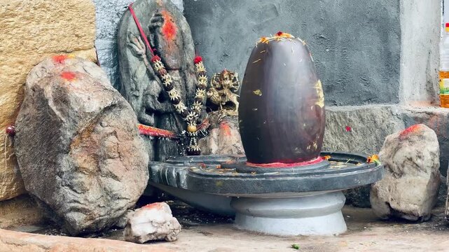 Sacred Shiva Lingam adorned with flowers and ritual offerings inside a Hindu temple, symbolizing devotion, spirituality, and the worship of Lord Shiva.