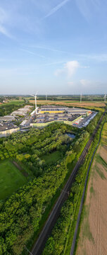 Aerial view of modern Colruyt distribution center with wind turbines in Halle, Belgi&euml; showcasing sustainable logistics and green energy integration