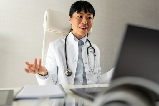 Female physician speaking during online consultation from clinic office. Telemedicine, healthcare communication, patient support and modern digital healthcare services.