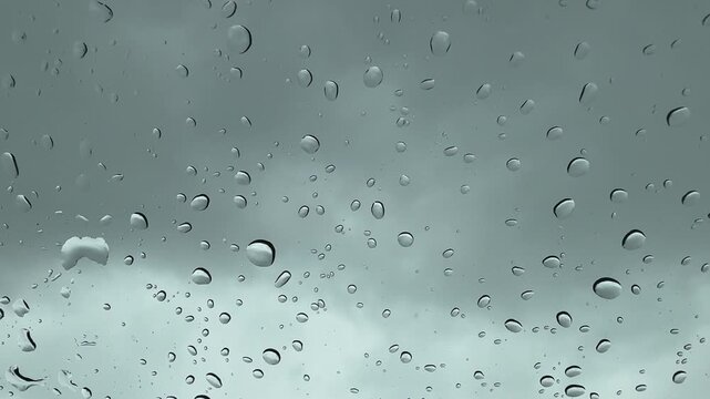 Accumulating Raindrops on Window Glass with Overcast Sky Background