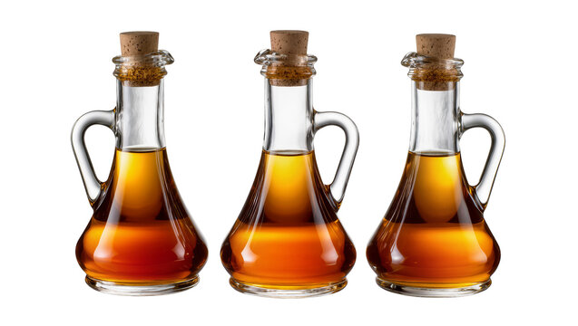 Three glass cruets with cork stoppers filled with amber liquid