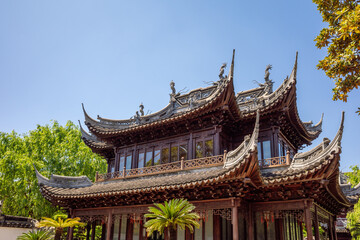 Obraz premium Traditional Multi-Tiered Chinese Pavilion with Ornate Dragon Eaves and Tiled Roof at Yu Garden in Shanghai, China.