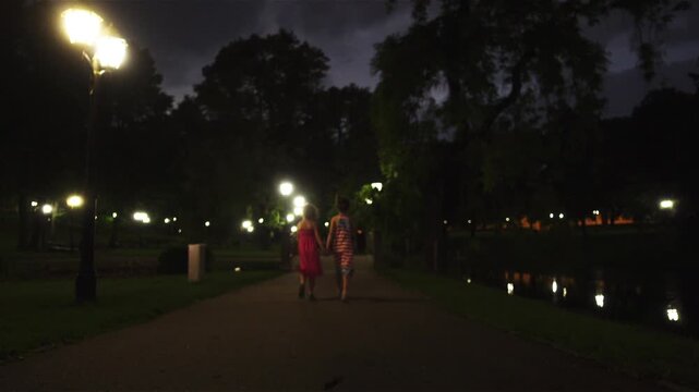 Two little girls walk near Bastion hill in Riga