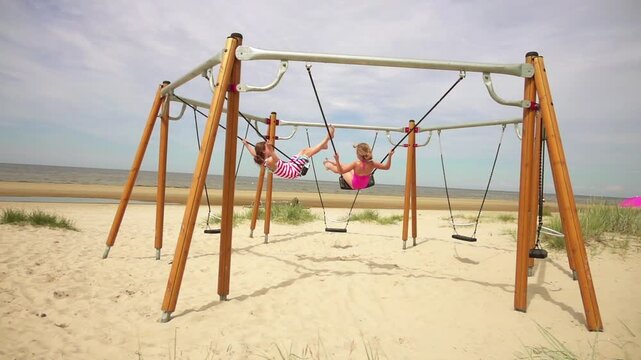 Beautiful little girl on swing Baltic Sea