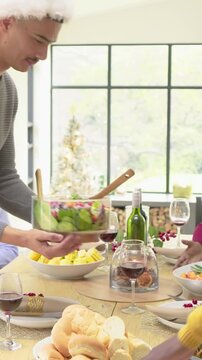 Vertical video: Roasting pan arriving gray-sweater server arranging salad for holiday meal at home
