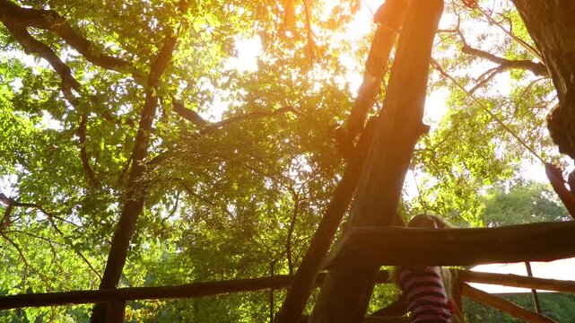 Little girls swing on a swing in a summer green park.