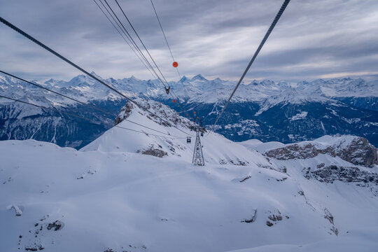 Panoramic view from top station of Funitel Violettes-Plaine Morte with aerial lift pylon in Crans-Montana, Switzerland over Rhone Valley towards Matterhorn mountain against cloudy skys