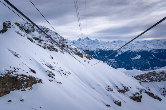 Panoramic view from Funitel Violettes-Plaine Morte with aerial lift pylon in Crans-Montana, Switzerland over Rhone Valley towards Matterhorn mountain against cloudy skys