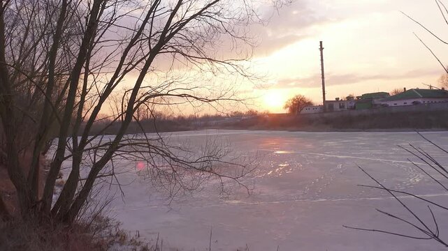 Two beautiful sisters against the background of the icing winter pond near the city.
