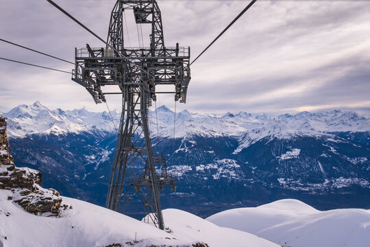 Panoramic view from Funitel Violettes-Plaine Morte with aerial lift pylon in Crans-Montana, Switzerland over Rhone Valley towards Val d'Anniviers against cloudy skys