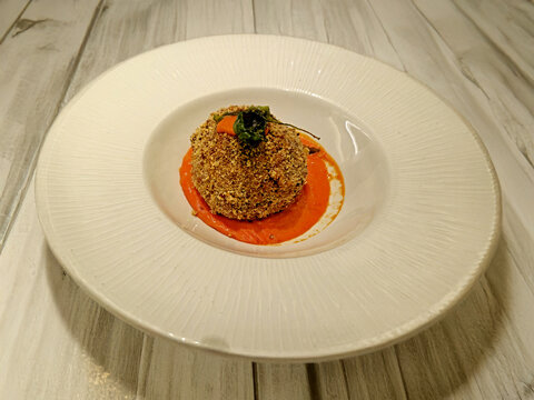 Polpetta gourmet croccante servita su specchio di salsa al pomodoro in piatto elegante 5507