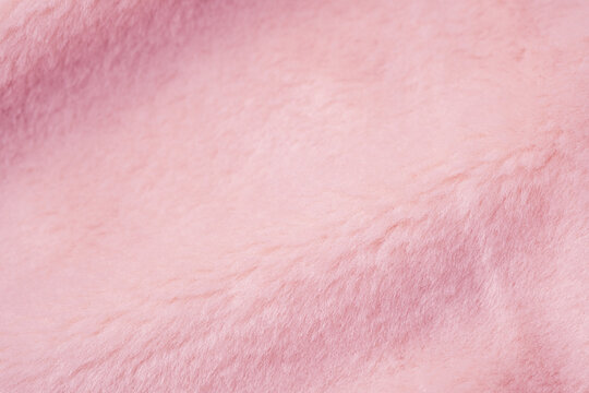 Close up detail of soft fluffy light pink synthetic fur material surface texture background pattern