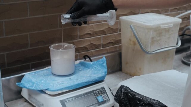 Dental technician preparing plaster material for creating a dental cast in a modern laboratory