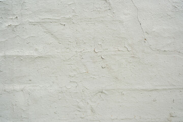 Obraz premium Old white wall background with cracked textured paint showing brick pattern