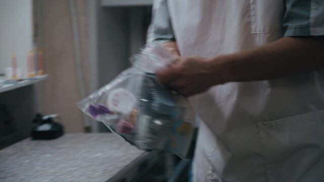 prosthetics maker organizes finished dental models into labeled bags, grouping them by the dentist's name and due date