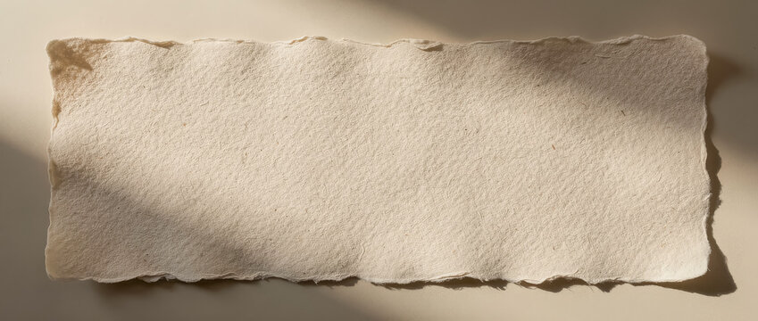 Empty handmade paper banner with torn edges and warm shadows