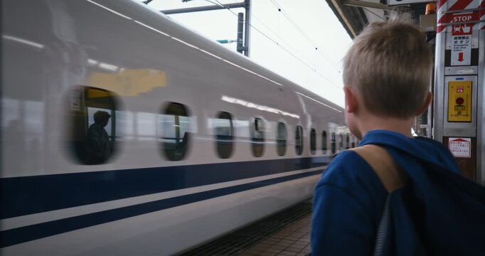 Child with Backpack Standing At Platform Edge As Bullet Train Passes Through - Medium Shot