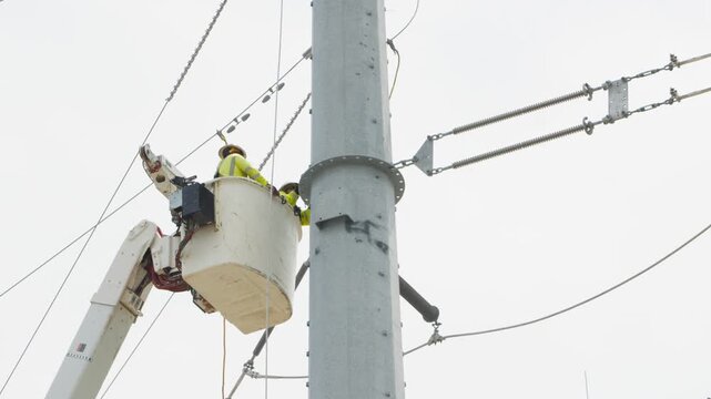 Electrical power linemen in bucket lift