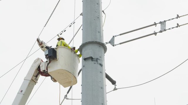 Electrical power linemen in bucket lift