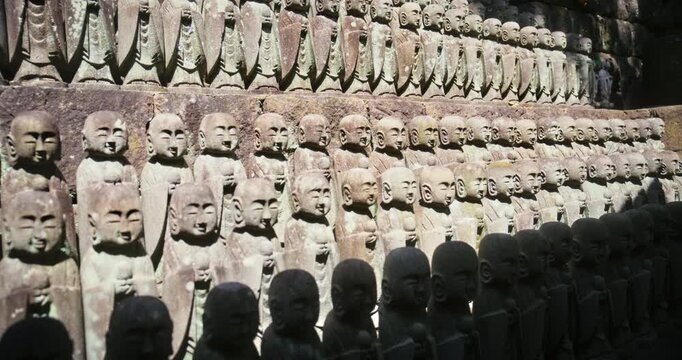Hundreds of Jizo Stone Statues Tiered Wall, Diagonal, Sunlight - Steady Cam
